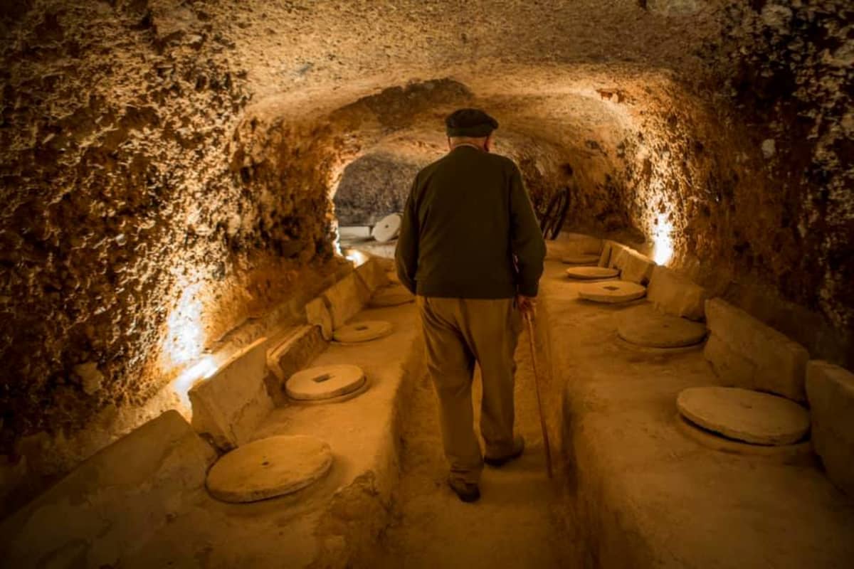 older man walking through winery caves