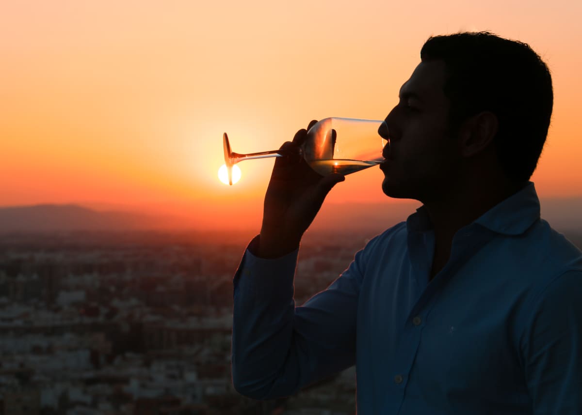 man drinking wine at sunset