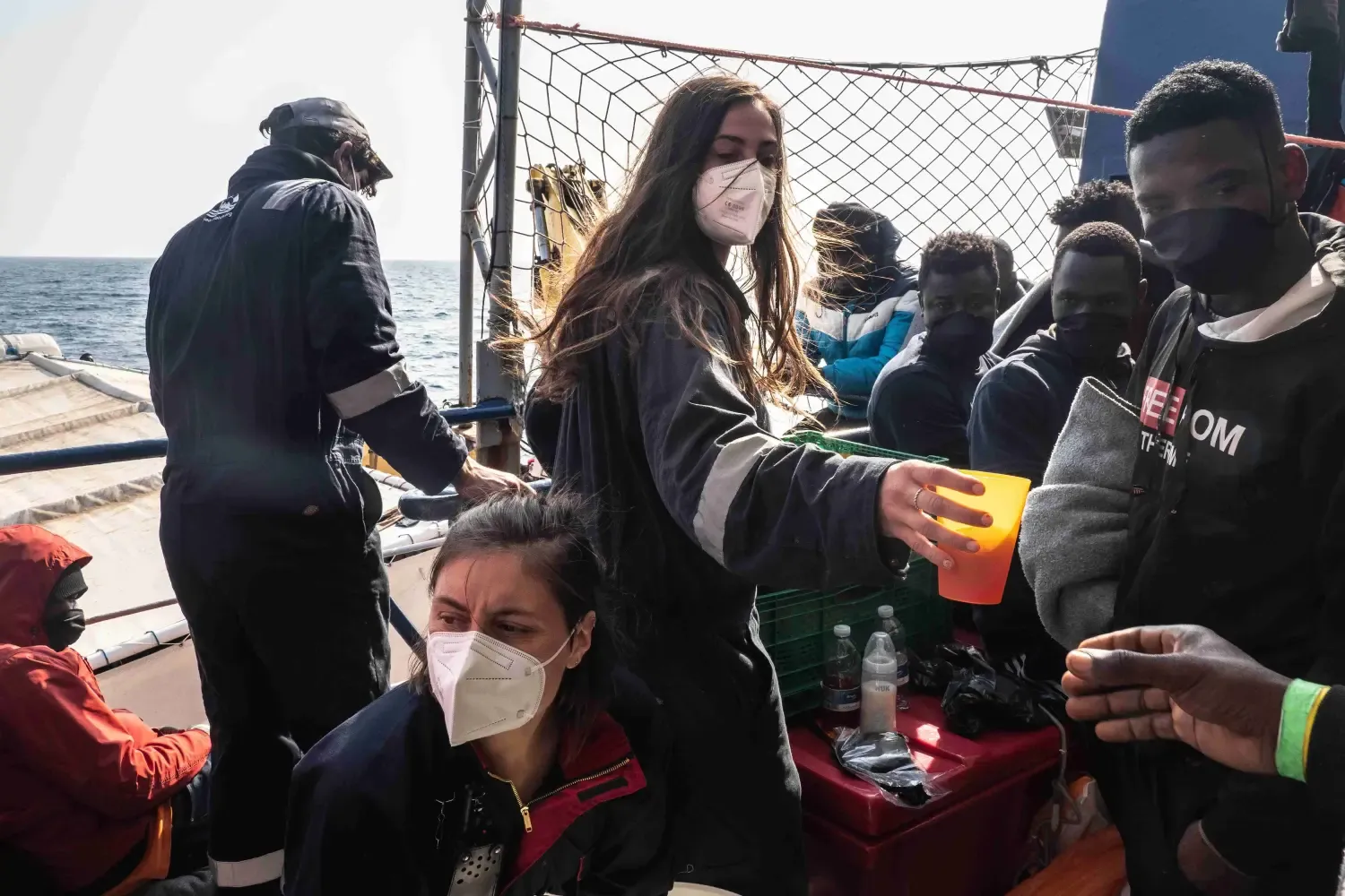 Sea-Watch Crew Mitglied verteilt Wasser an Bord.