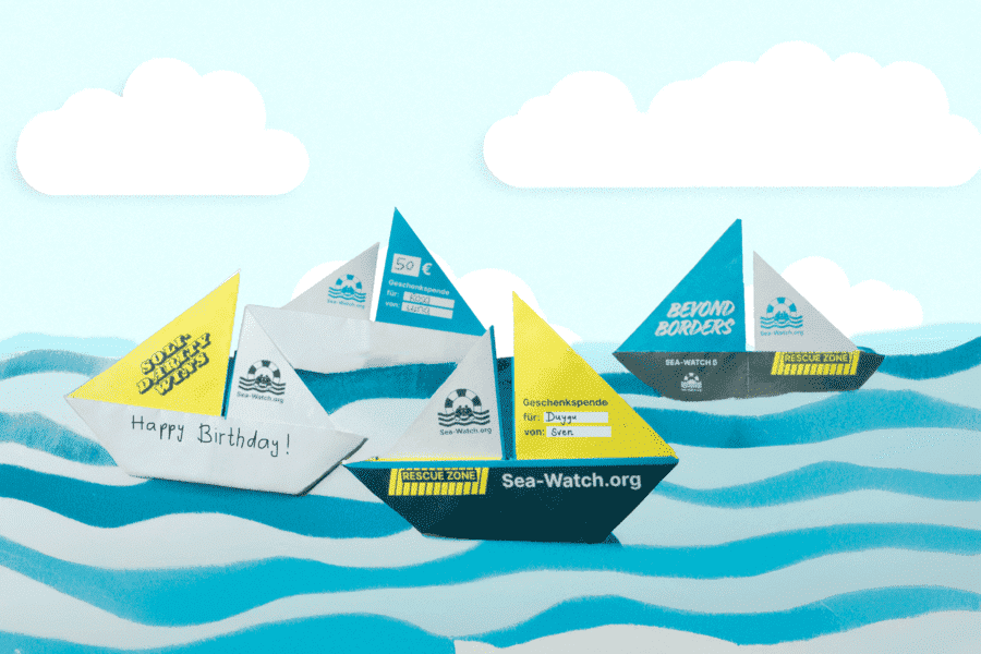 Illustration von Papierbooten auf blauen Wellen mit Aufschriften wie „Sea-Watch.org“, „Solidarity Saves Lives“ und „Happy Birthday!“.