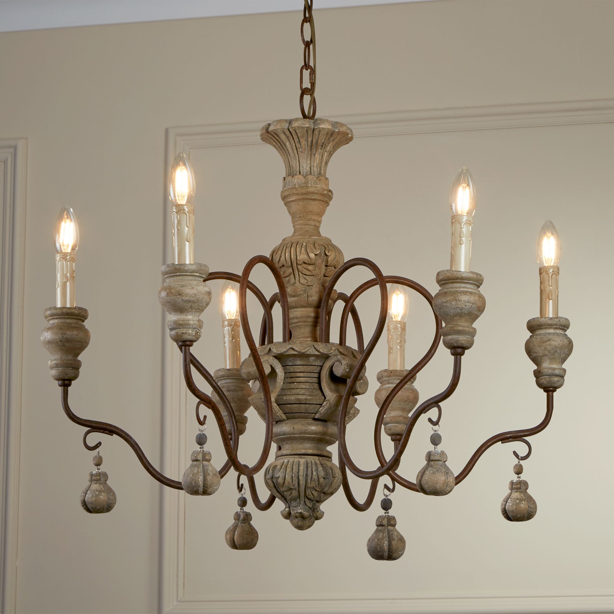 Brown Traditional Ceiling Pendant Light the body has a textured design and then proceeds to rustic brown arched arms that house candle holders hang from a high ceiling in a traditional home