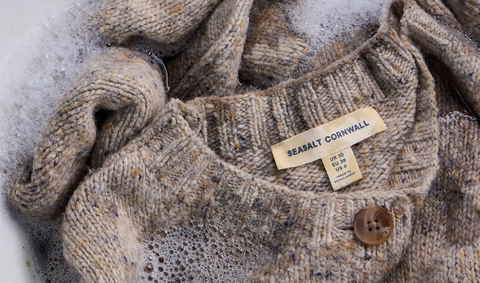A close of up some bubbly knitwear being washed in a bowl