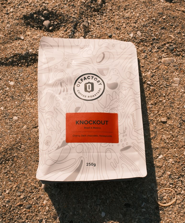 Bag of Olfactory KNOCKOUT coffee pictured on the sand