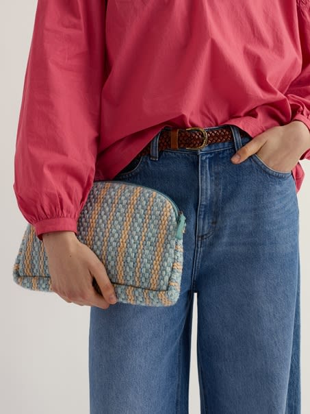 A close up of a woman holding our Flourish Cross Body Bag in Sardine.
