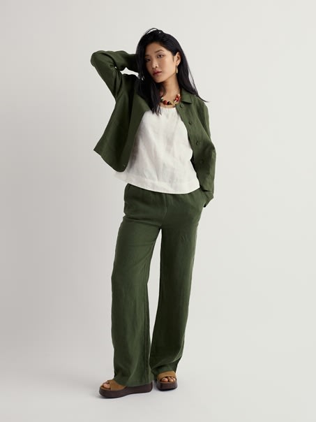 A model wearing our Tide Flow Trouser in Hosta and a matching green blazer.