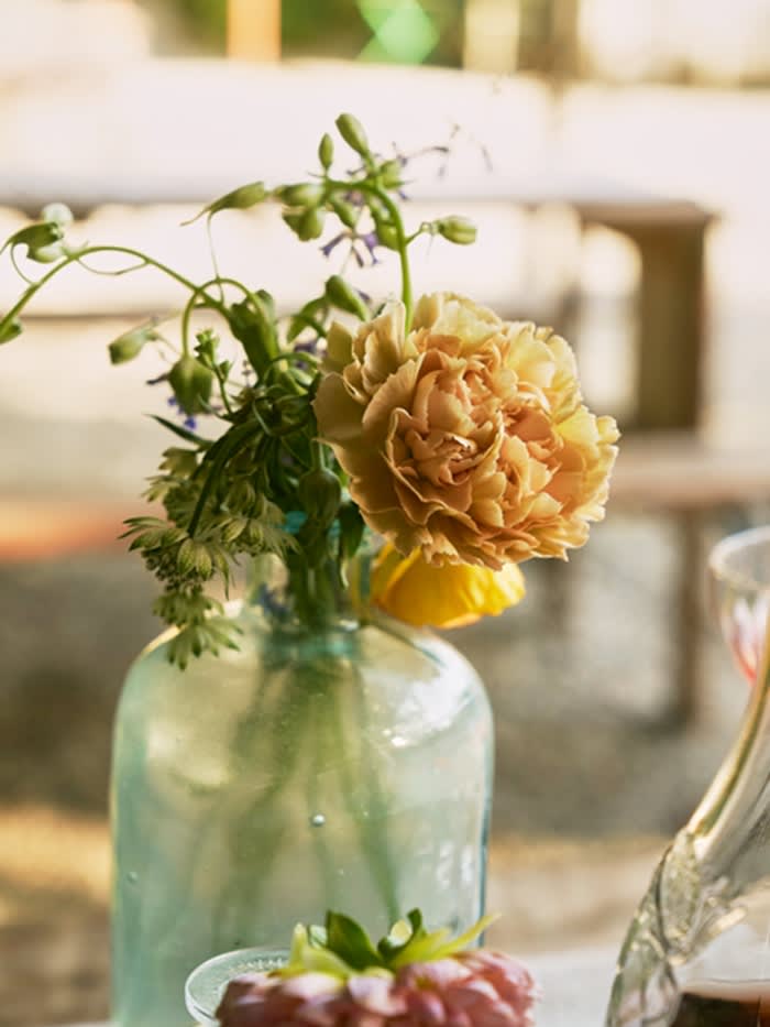 A close up of yellow flowers in a glass vase.