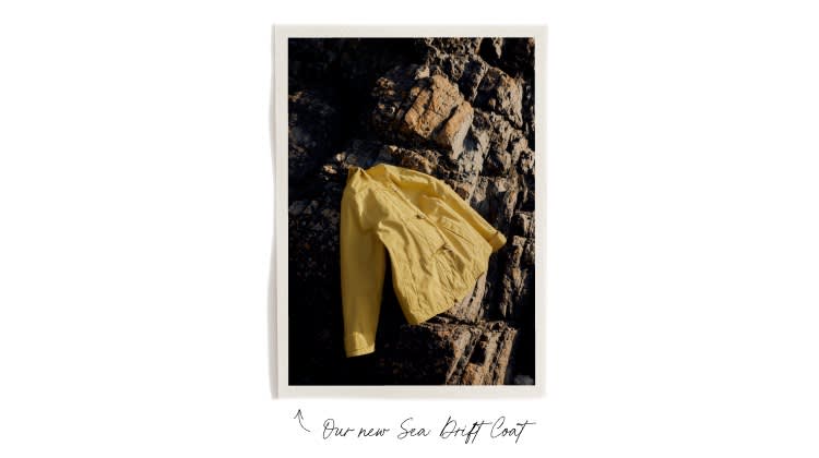 The yellow Seasalt Sea Drift coat on some rocks 