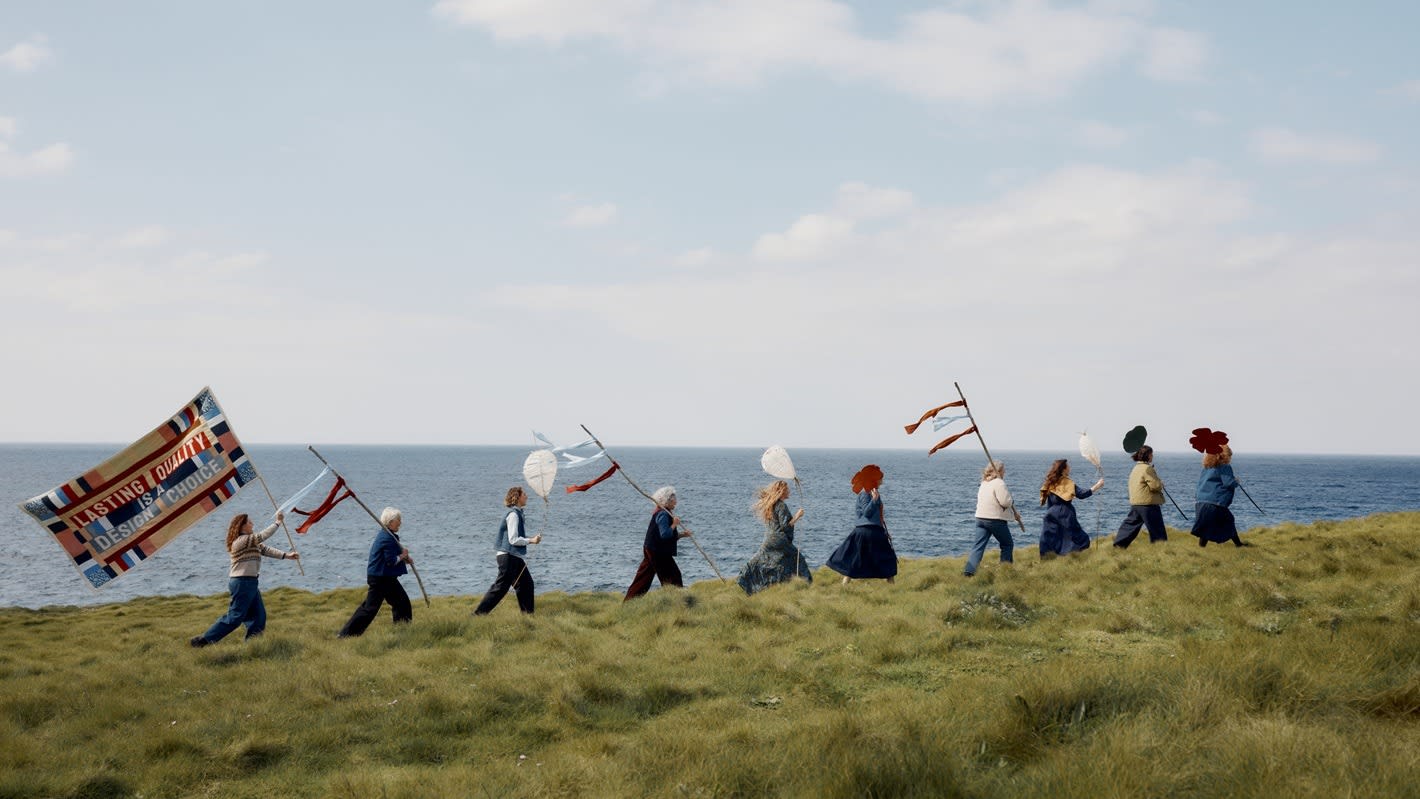 Femmes De La Mer walking across the cliffs in a line, wearing Seasalt and carrying lanterns and large flowers
