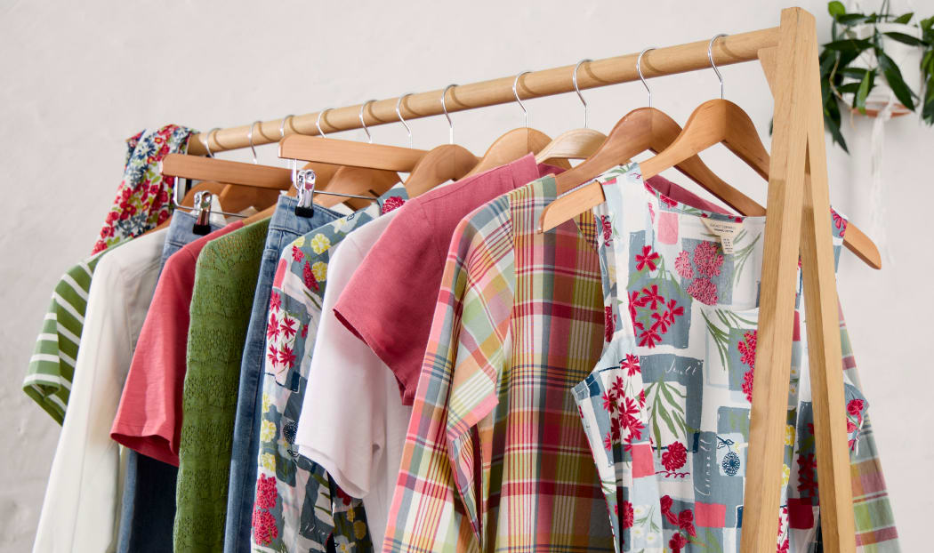 A rail of clothes in shades of pastel pink and green A rail of clothes from Seasalt's spring collection in shades of pastel pink and green