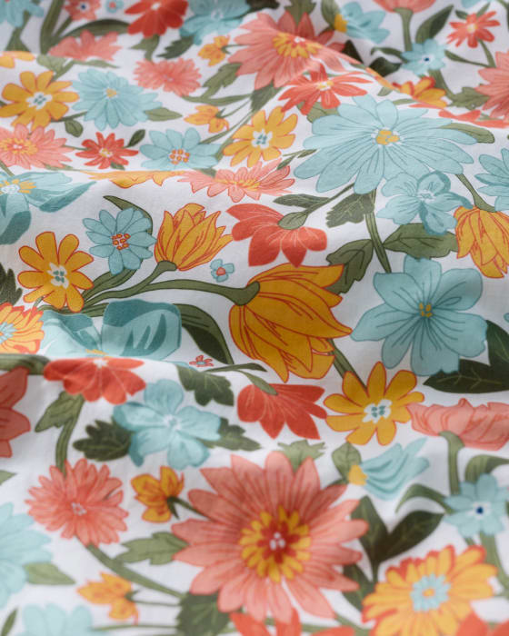 Seasalt's Retro Floral Print A close up of a retro floral print in shades of pastel orange, pink and blue