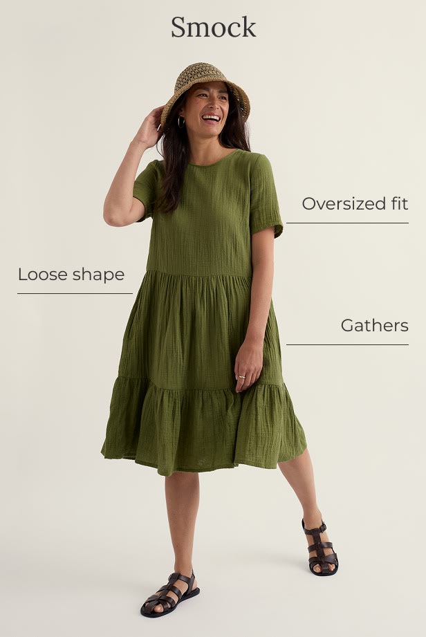 A model wears a sun hat with a green smock dress