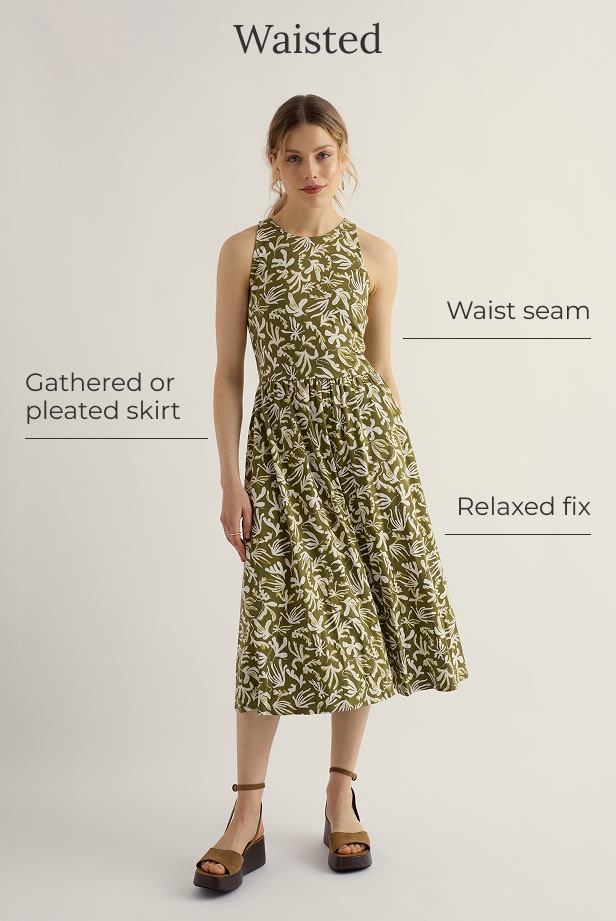 A model wears a waisted green dress with a white floral pattern