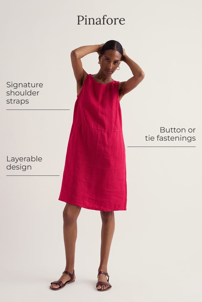 A model wears a hot pink mini pinafore dress with a pair of brown sandals