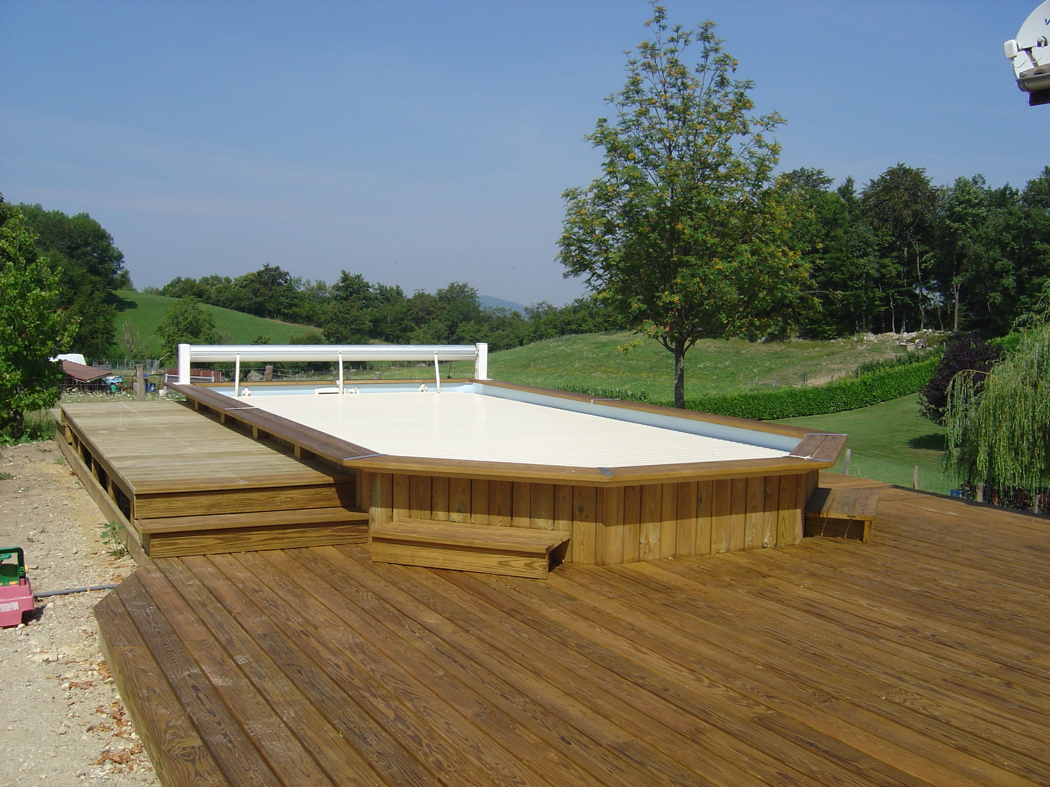 Piscine avec deck en bois et rideau de protection