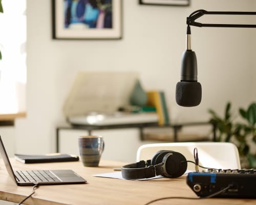 Enregistrement d’un podcast d’entrepreneurs avec micro, smartphone et carnet de notes