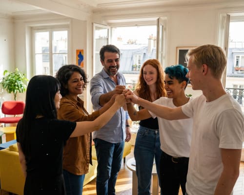 Trois jeunes adultes jouent à un jeu de blocs en bois sur une table en extérieur