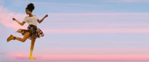 Girl floating in sky on one skate