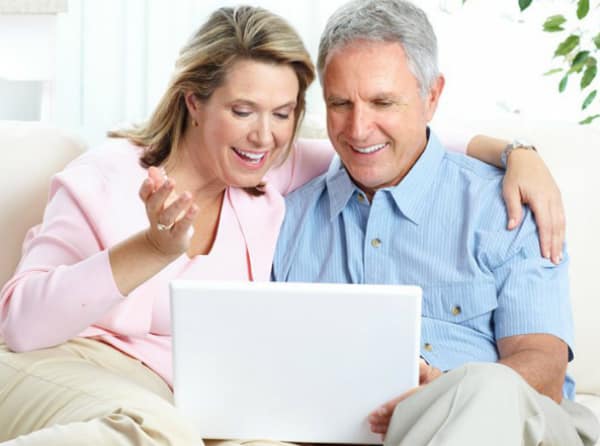 Couple qui regarde un ordinateur avec un sourire