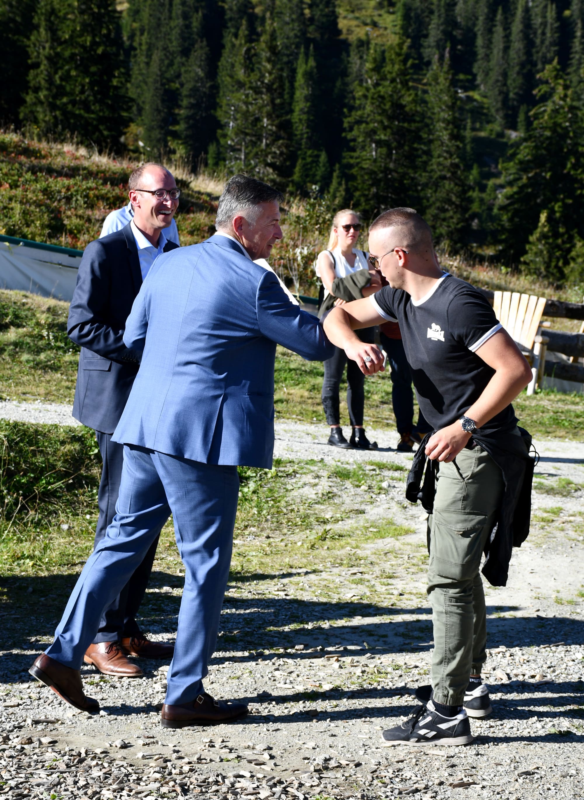Le président de Remontées Mécaniques Suisses et conseiller aux États Hans Wicki félicite un diplômé dans le respect des mesures de protection dues au coronavirus. Martin Candinas (derrière à gauche), conseiller national grison, a également pris part à la cérémonie. (Photo: RMS)