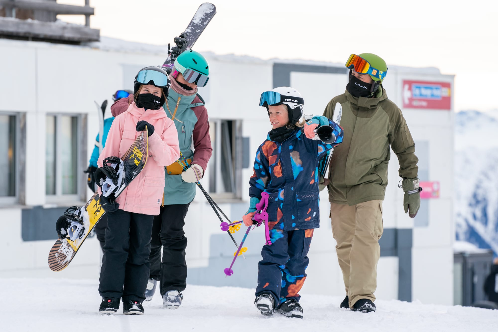 Kinder bei der Bergstation in Laax mit Ski und Snowboard