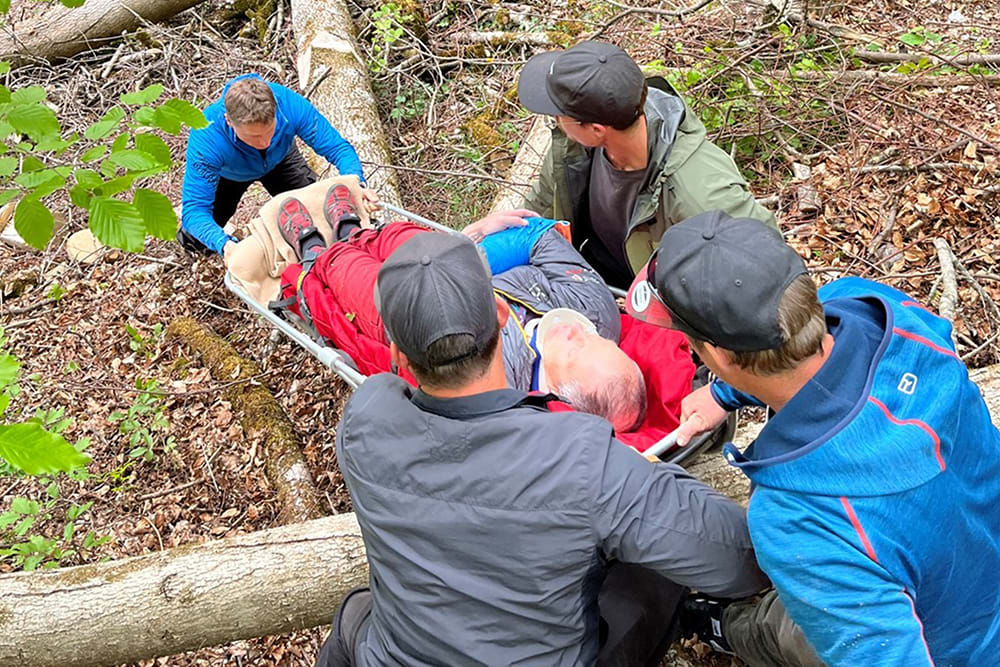Dans la partie pratique du cours central A - été, les participants apprennent à dégager des personnes accidentées dans le terrain. Photo : Philipp Ramseyer.