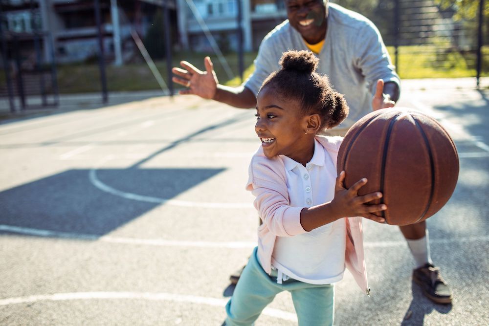 A little girl plays basketball