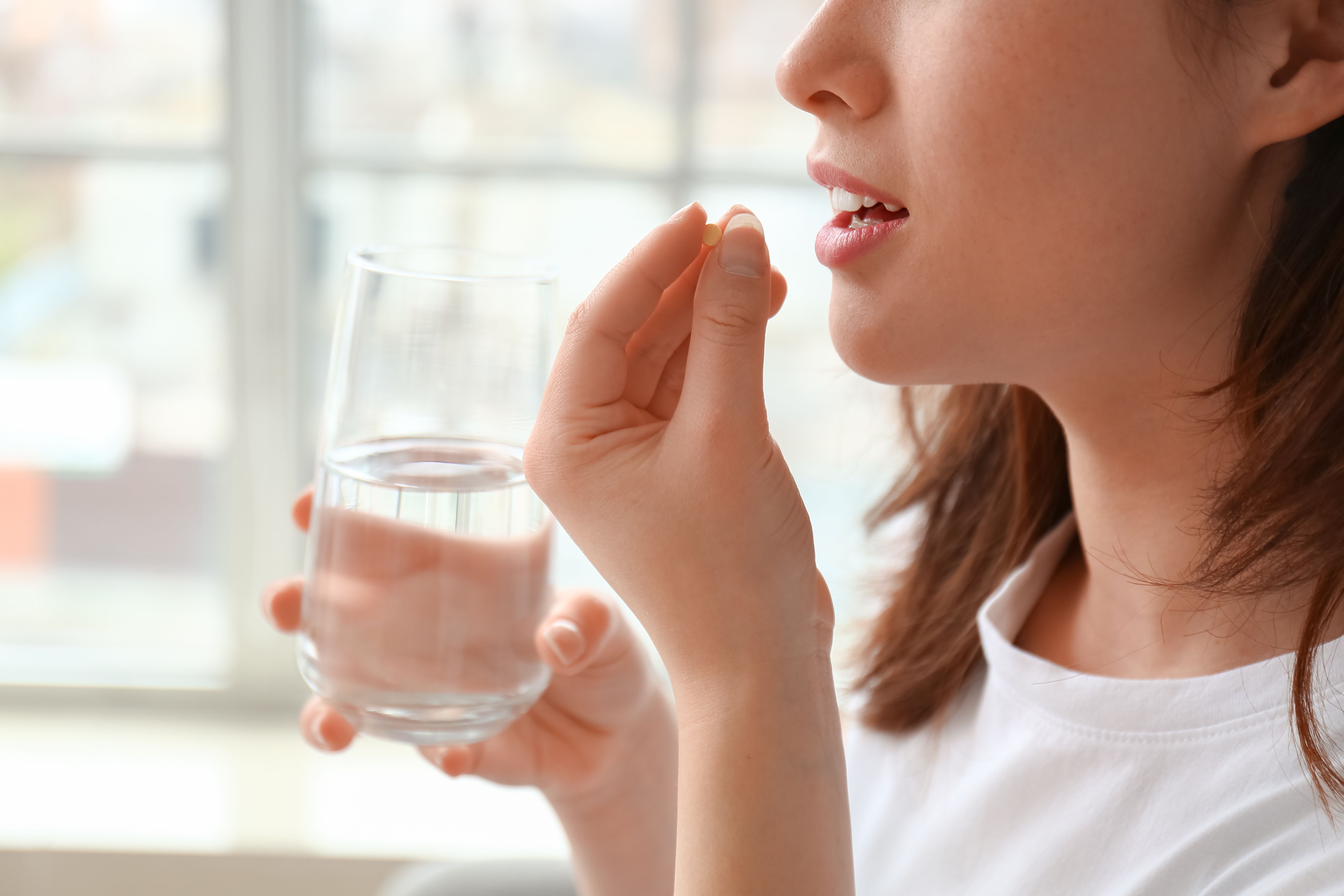 woman taking oral medication