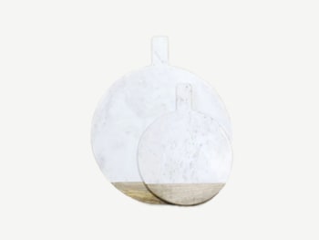 Round white marble cutting boards with a mango wood edge on the bottom.