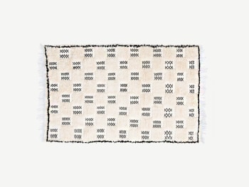 Beige wool rug with a fine black checkered pattern.