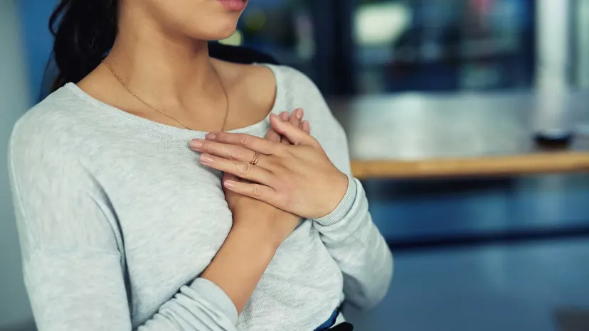 Woman clutching her aching chest.