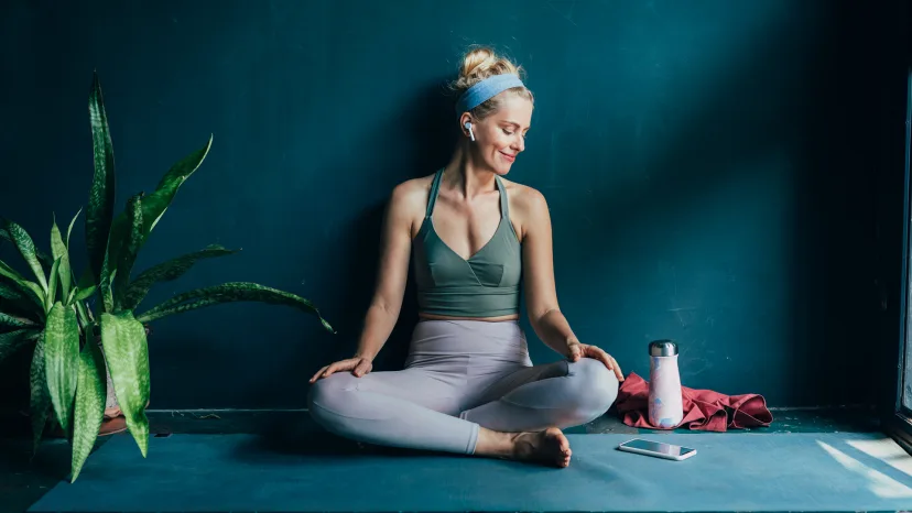 Woman looking at her phone between yoga poses.