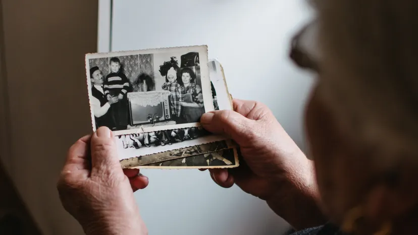 Older woman looking at old pictures from her childhood.