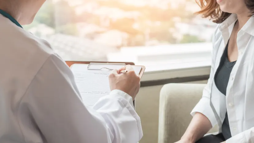 woman sitting with a doctor listening to information about menopause, faces out of view