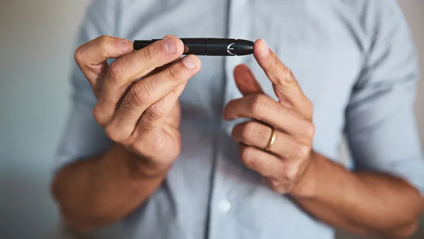Man testing his blood sugar with a finger prick machine.