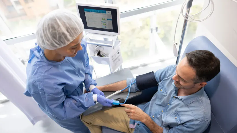 Latin American nurse checking the vital signs of a patient at the hospital during a medical exam