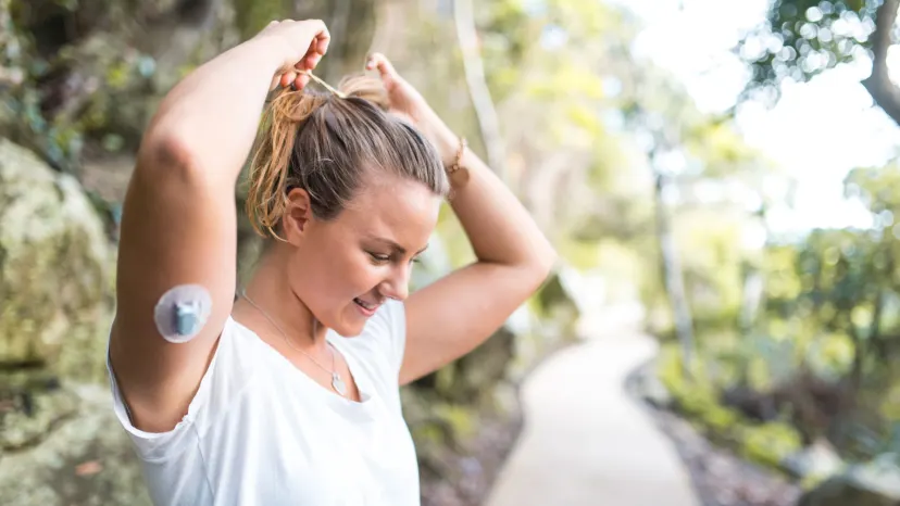 Diabetic young woman preparing for a run in a green outdoor area