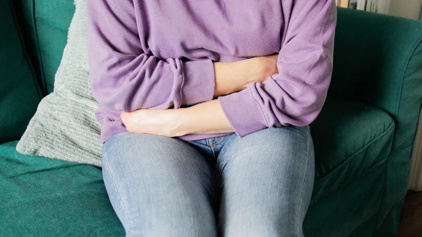 Woman with ovarian cancer holding her abdomen in pain 