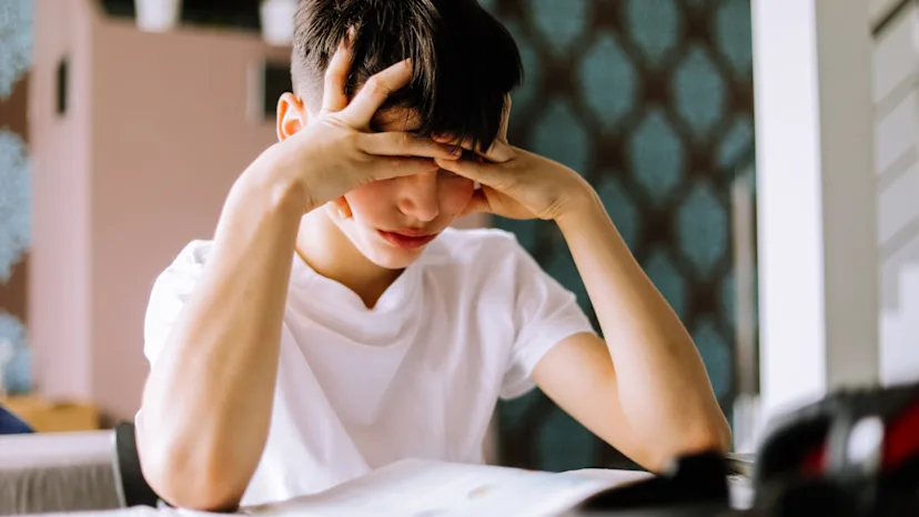 Boy with ADHD feeling frustrated as he does school work