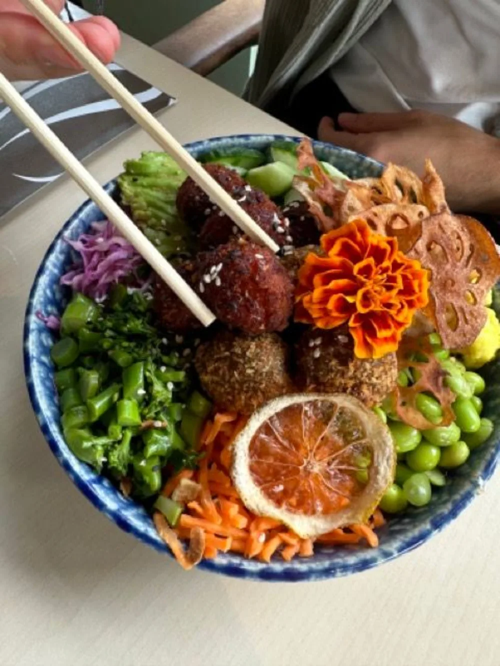 Een vegan pokebowl met daarop een bloem