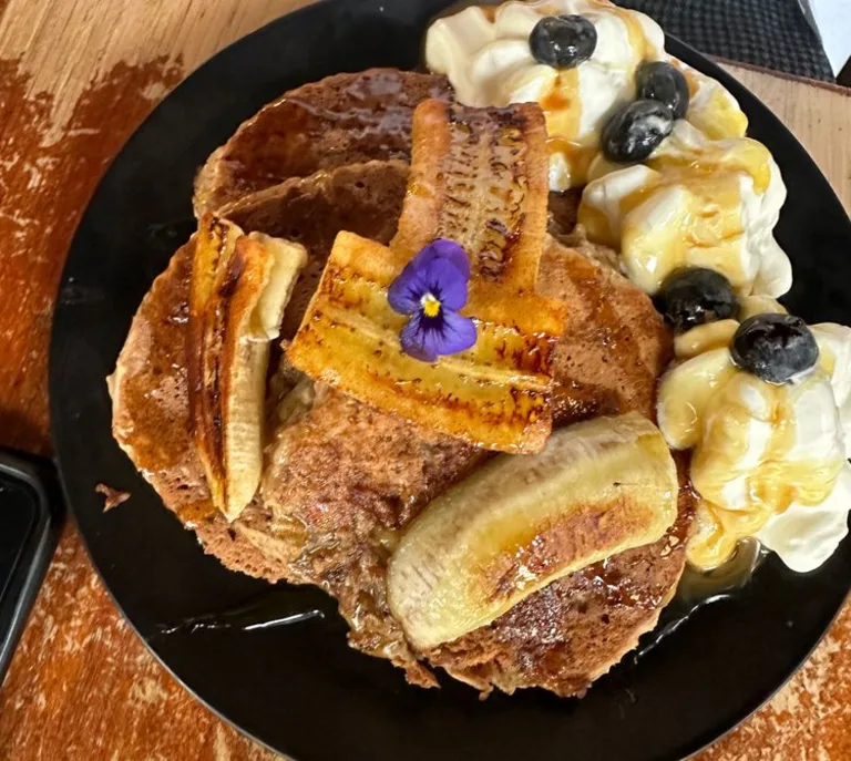 Een bord met pancakes en gekarameliseerde banaan