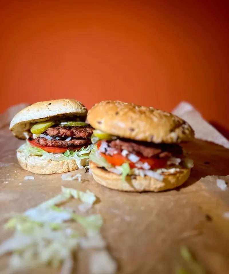 Voor een oranje achtergrond zie je twee smash burgers 