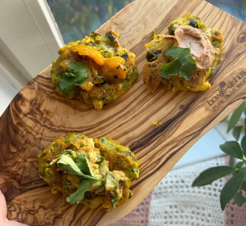 A wooden cutting board with 3 chickpea pancakes