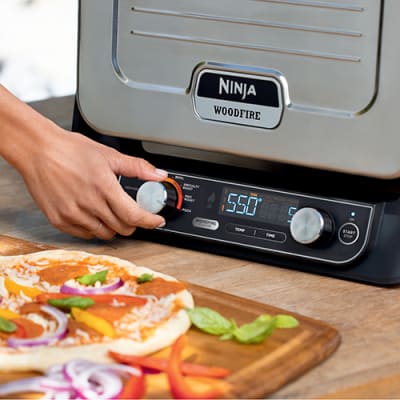 The Ninja Woodfire Electric Outdoor Oven is a pizza oven, BBQ and smoker in  one