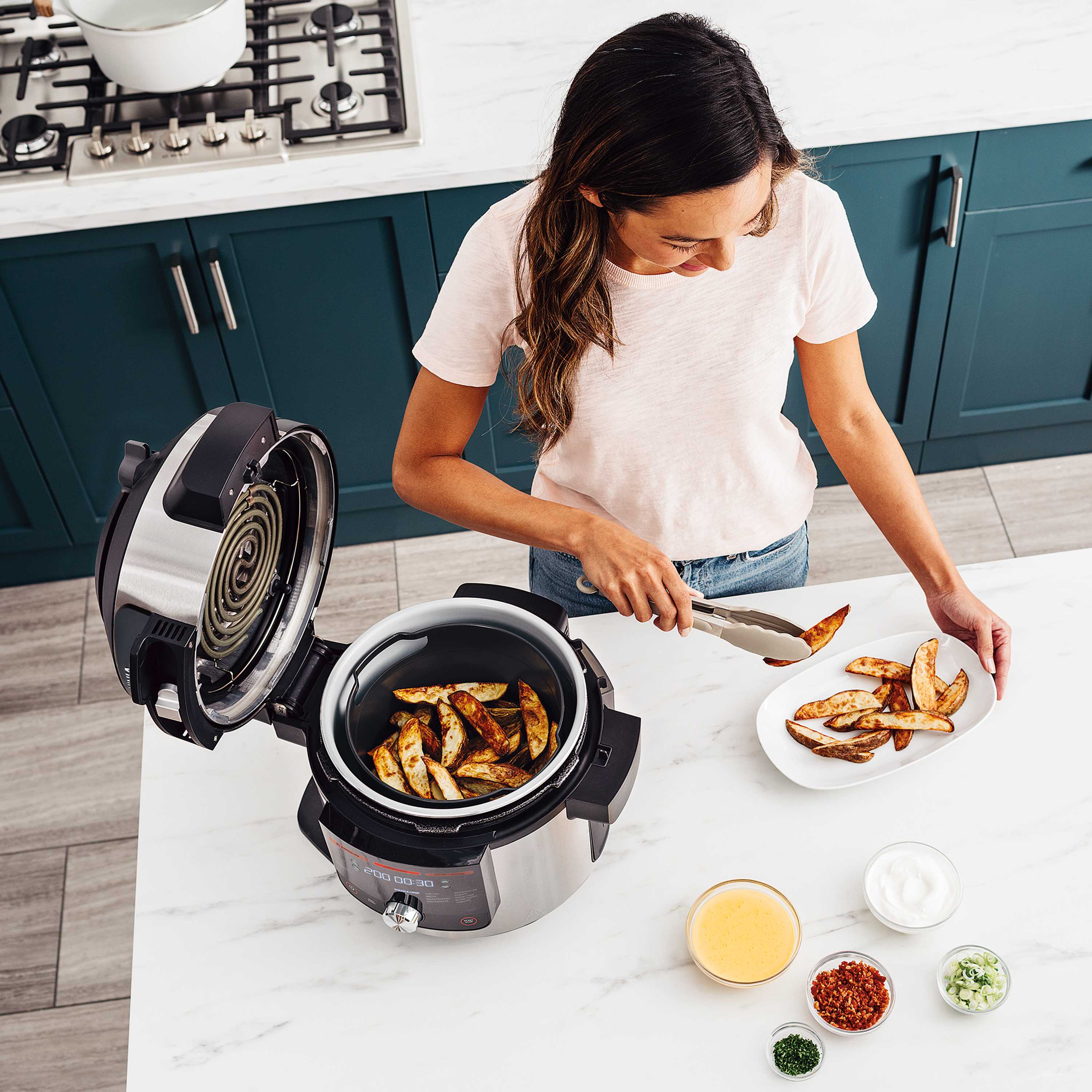 Imagen de una olla eléctrica Ninja en función Freidora con aire cocinando unas patatas fritas sin aceite