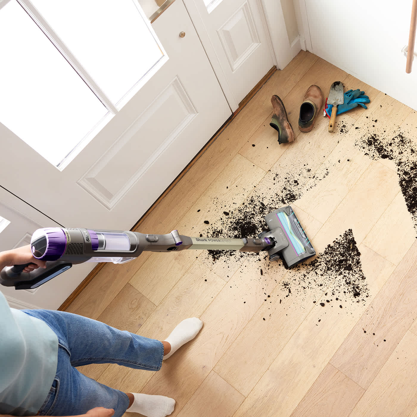 Des femmes nettoient la boue dans le couloir à l'aide de l'aspirateur sans fil PowerDetect