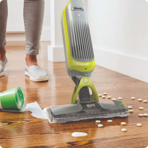 Person picking up spills on the kitchen floor with the Shark 2-in-1 Cordless Vacuum Mop