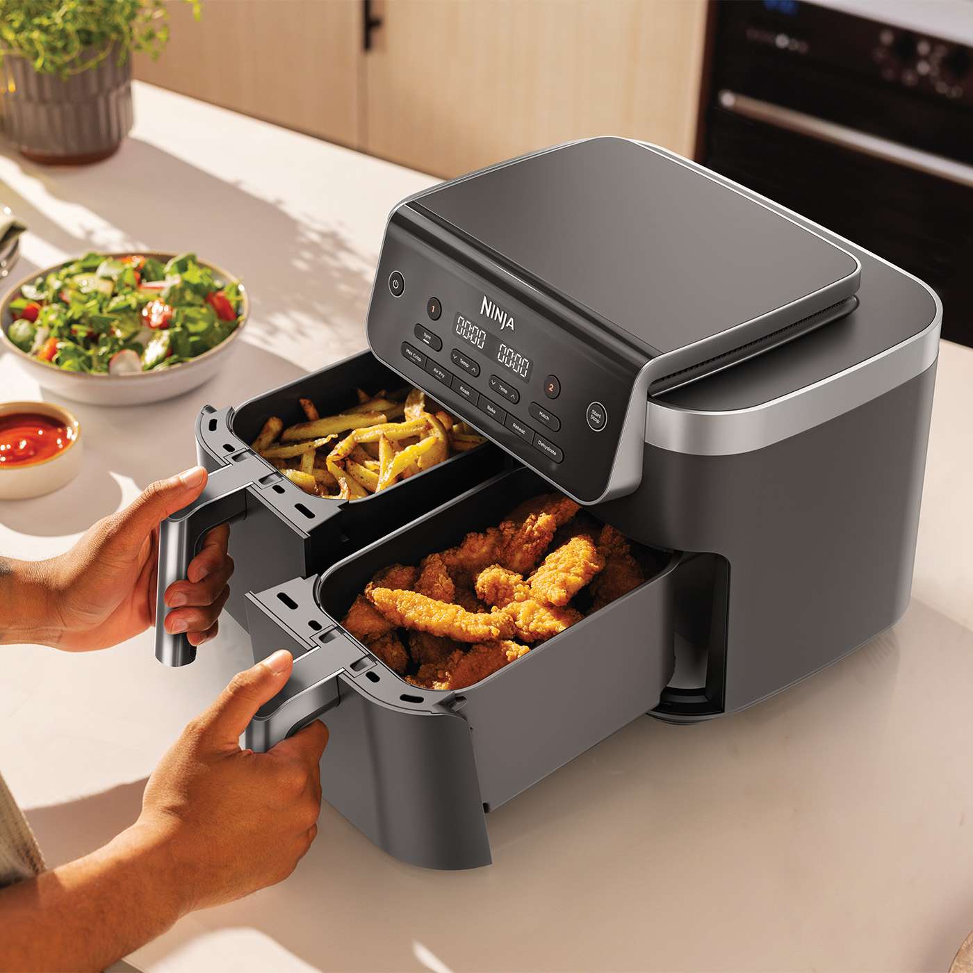 Die Hei&szlig;luftfritteuse mit zwei Schubladen, die zwei verschiedene Speisen gleichzeitig zubereiten kann
