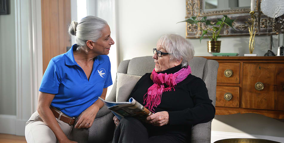 A Senior Home Care by Angels caregiver comforting an elderly woman with Alzheimer's, highlighting compassionate support in a peaceful home setting.