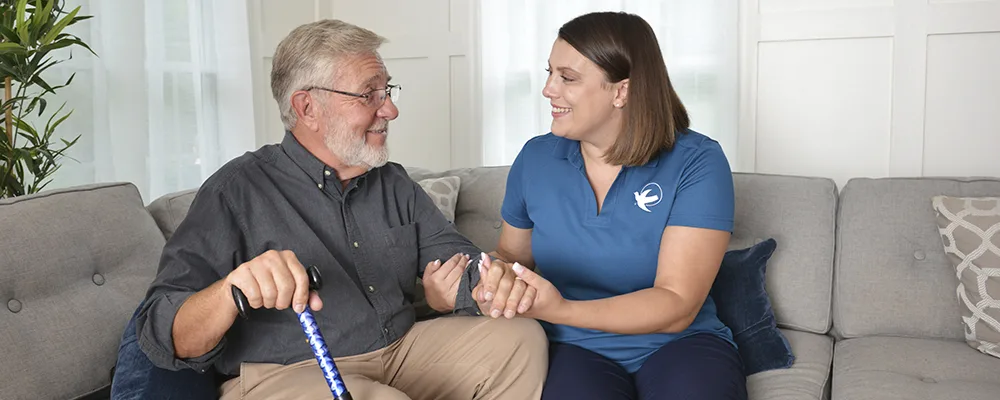 A Senior Home Care by Angels caregiver comforting an elderly woman with Alzheimer's, highlighting compassionate support in a peaceful home setting.