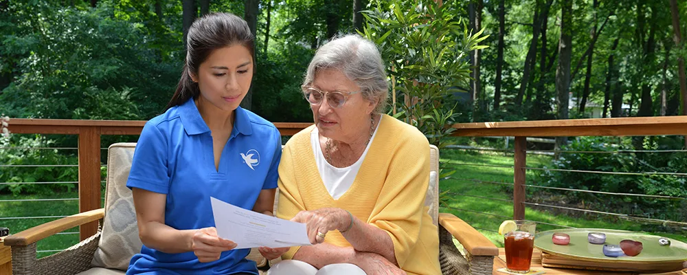 A Senior Home Care by Angels caregiver comforting an elderly woman with Alzheimer's, highlighting compassionate support in a peaceful home setting.